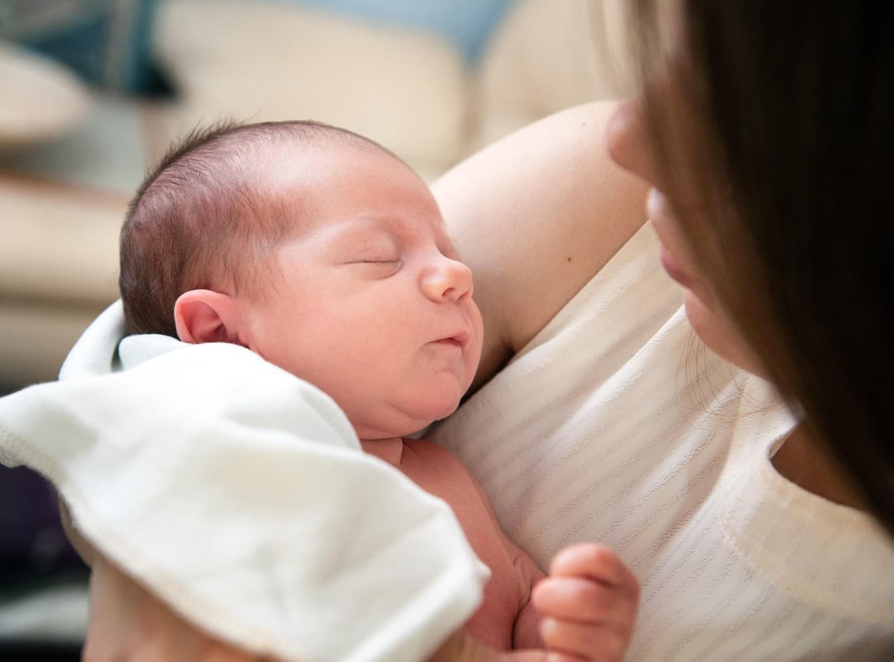 Child resting while recovering from stomach bug with parent nearby