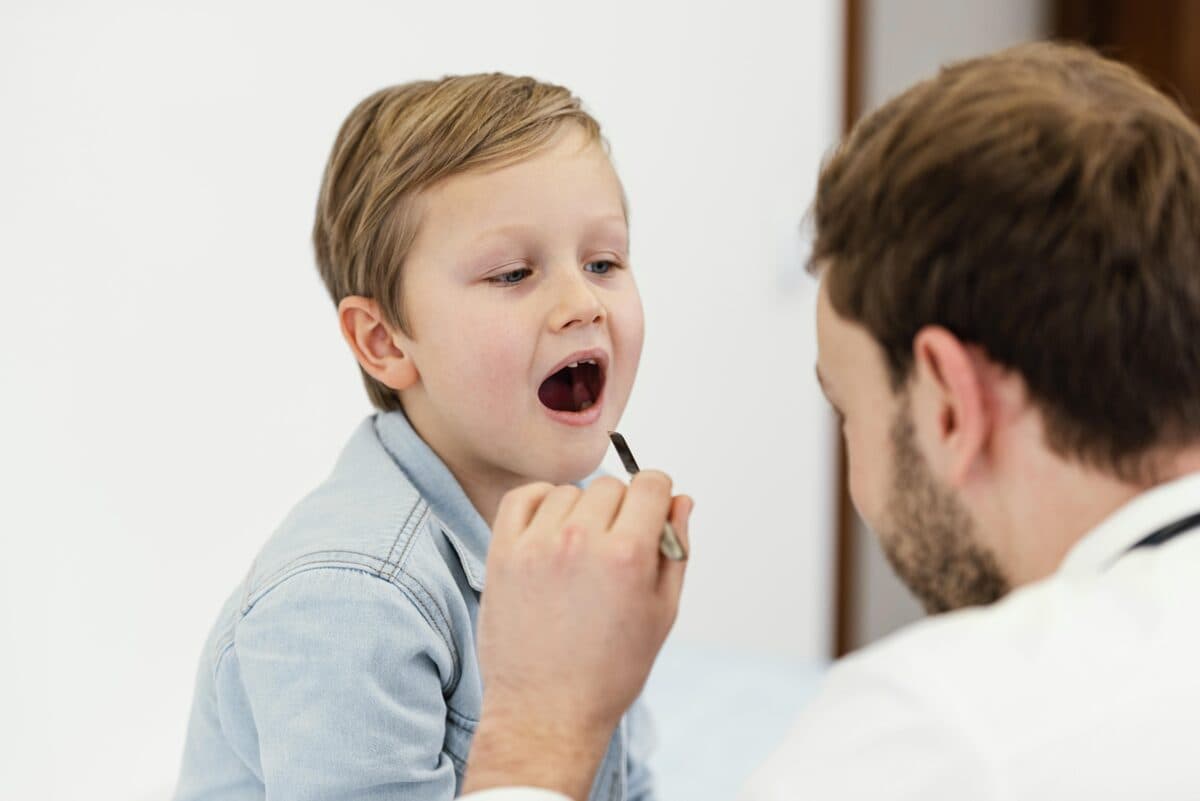 Parent using a fine-toothed nit comb on a child's hair near a bright window, checking for head lice
