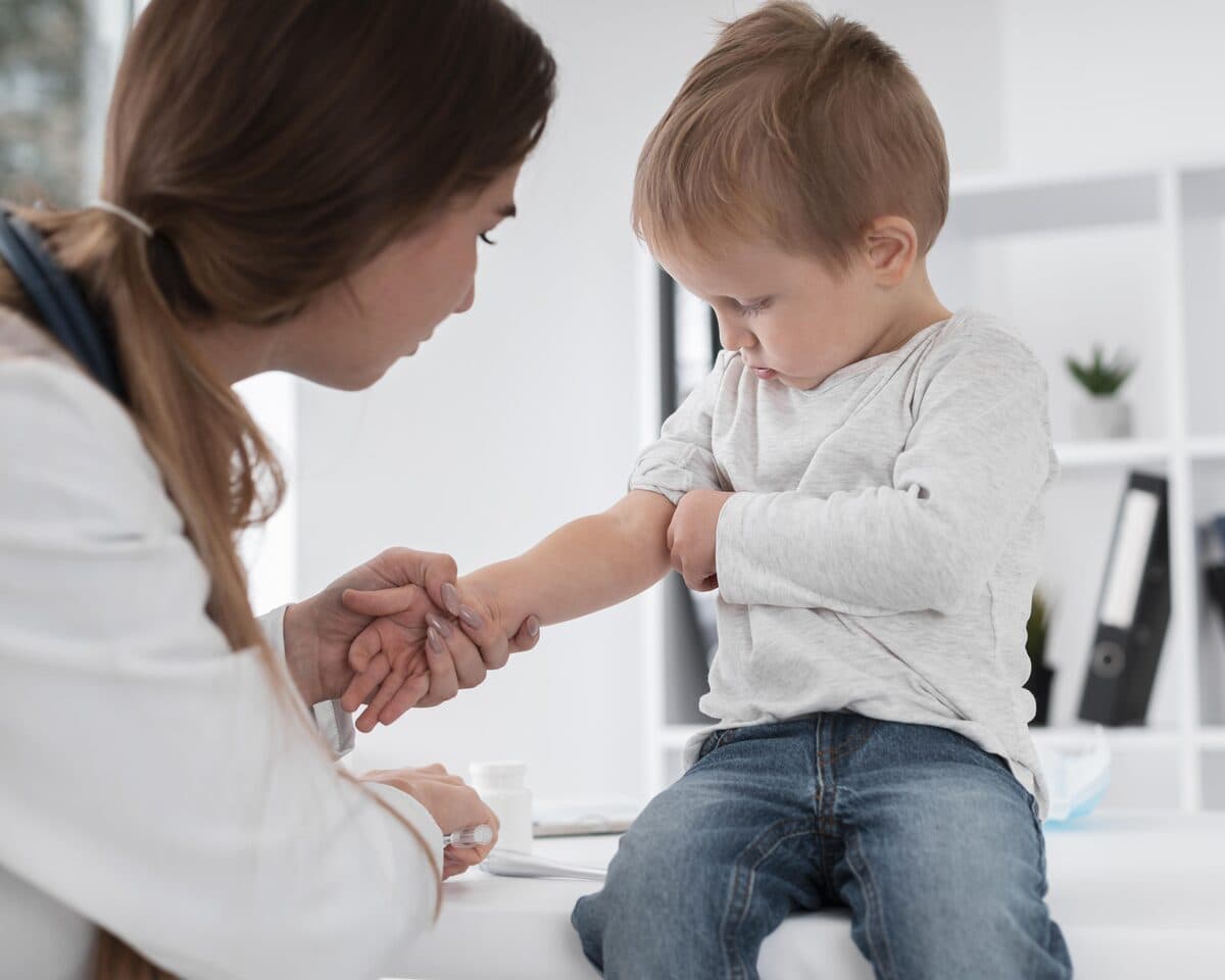 Parent holding an infant upright against their shoulder after feeding in a cozy nursery setting