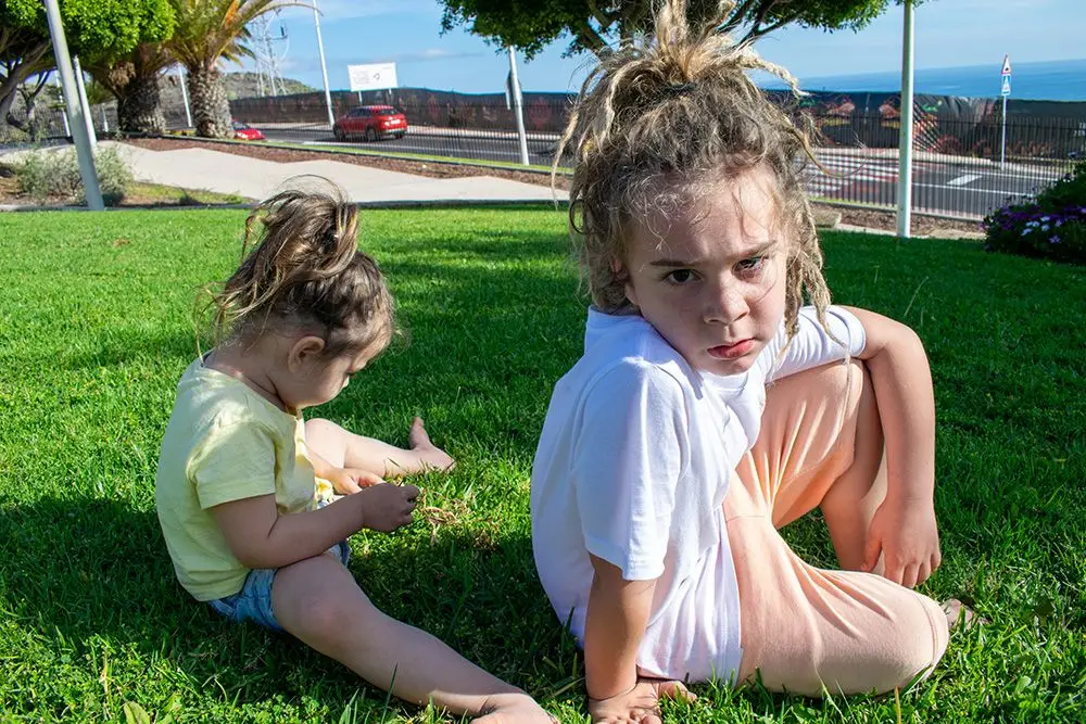 kids sitting on the grass outside, young boy with an attitude